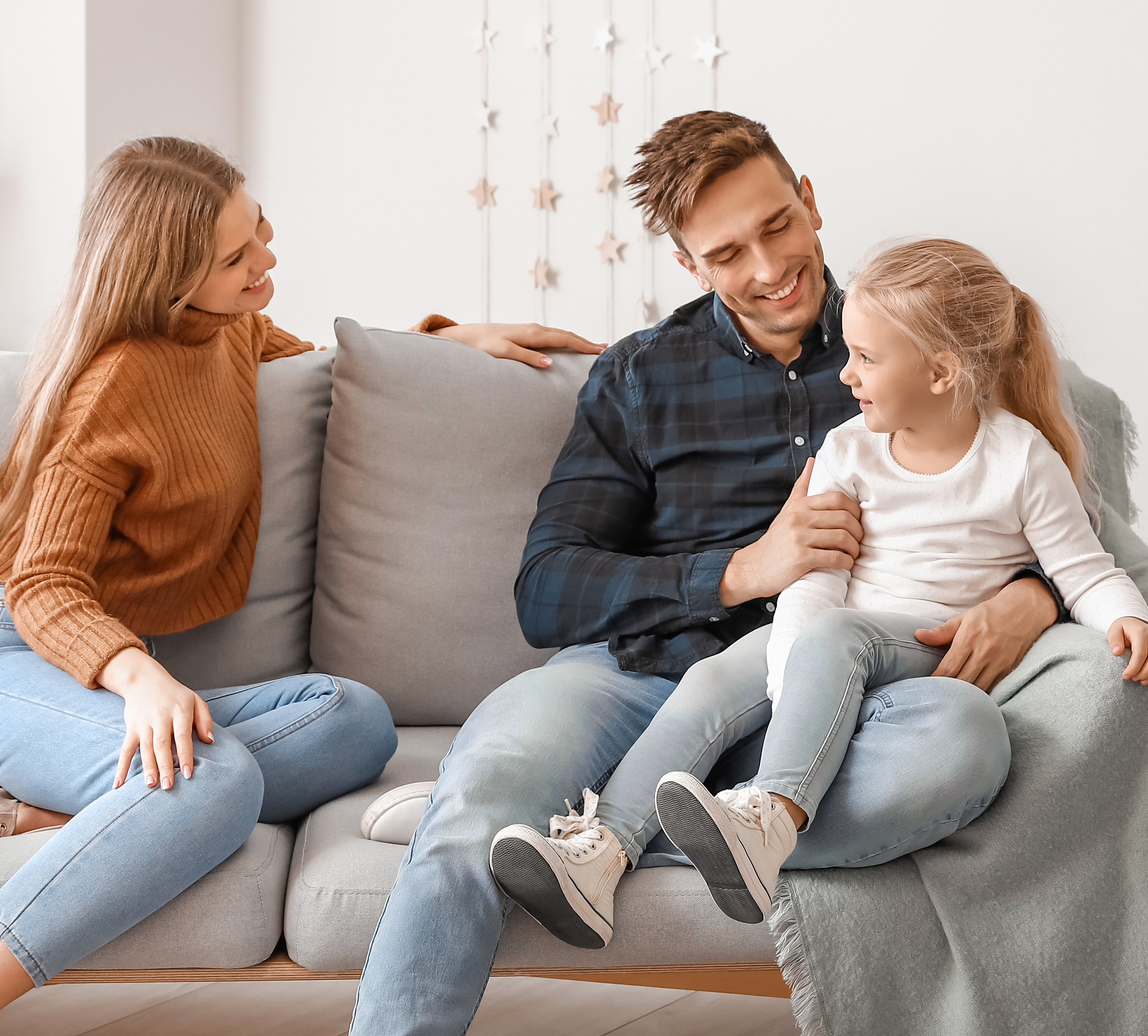 Happy young family sitting on sofa at home