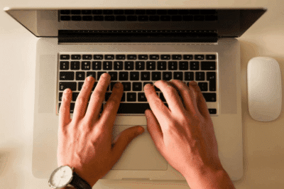 Hands typing on the laptop