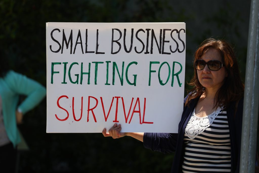 Business owner holding a sign